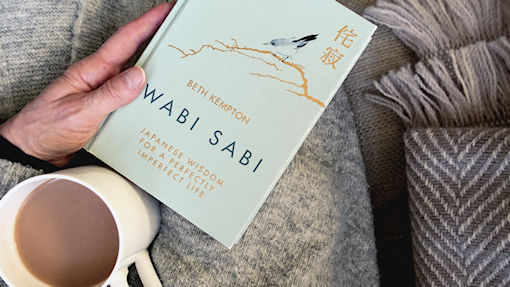 Wabi Sabi book on my lap with a brew and blanket