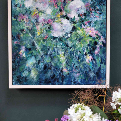 An English Country Garden is a framed abstract painting in a square format. It is shown hung on a dark wall and it fills the space with a little bit of magic